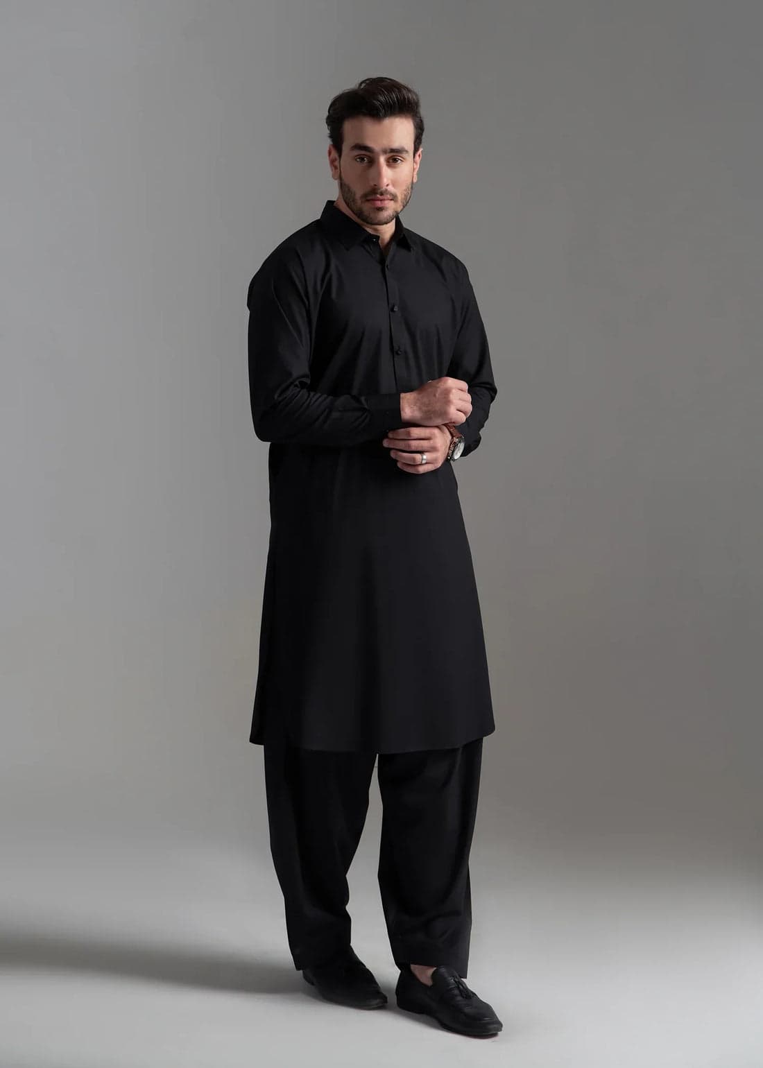 Menswear editorial — tailored black kurta on a studio set