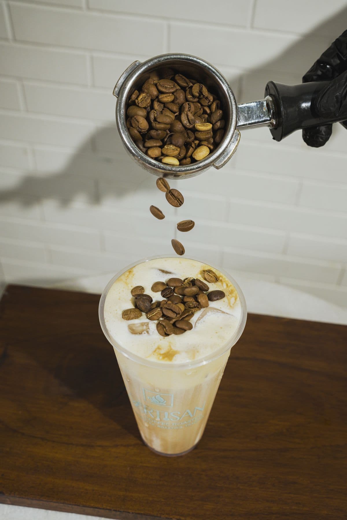 Coffee beans falling into an iced latte